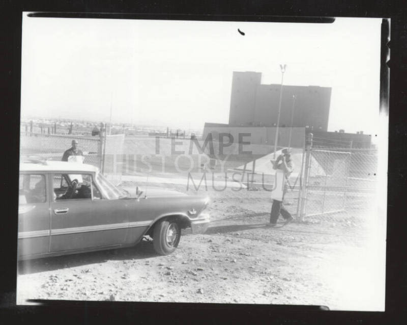 AFL-CIO organizers in front of a fence with a car