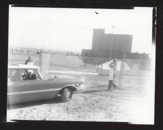AFL-CIO organizers in front of a fence with a car