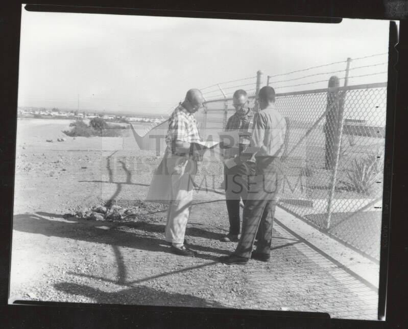 Three AFL-CIO union organizers standing next to chain link fence