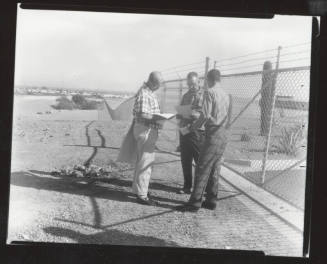 Three AFL-CIO union organizers standing next to chain link fence