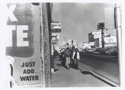 Draft protesters with signs walking down Mill Avenue
