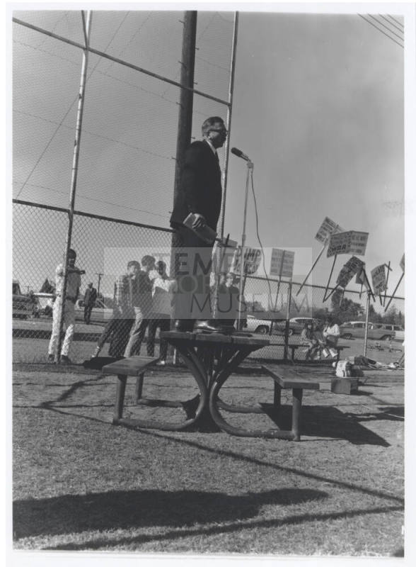 Draft protest march - man in suit standing on table with microphone