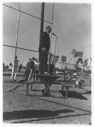 Draft protest march - man in suit standing on table with microphone