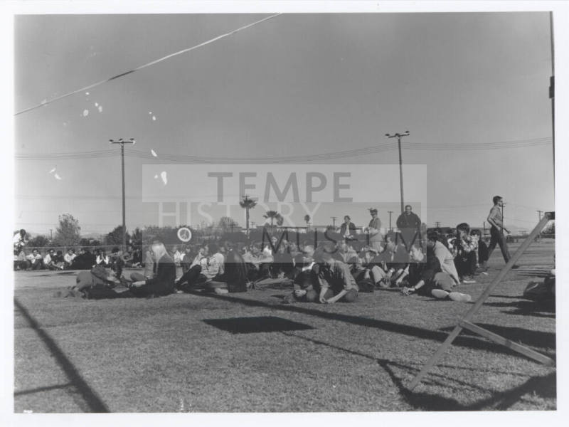 Crowd of anti-war protesters seated in the grass