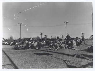 Crowd of anti-war protesters seated in the grass