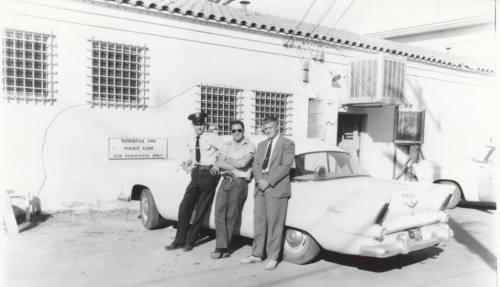 Uniformed police officer and two other men behind the Tempe Police Station.