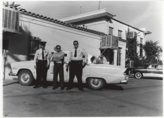 Two police officers and another man behind the Tempe Police station