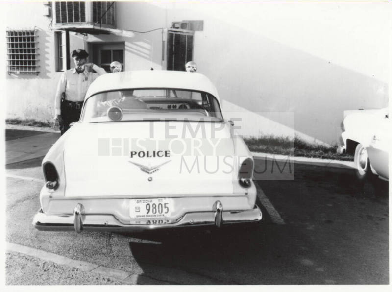 Police car and officer behind the Tempe police station