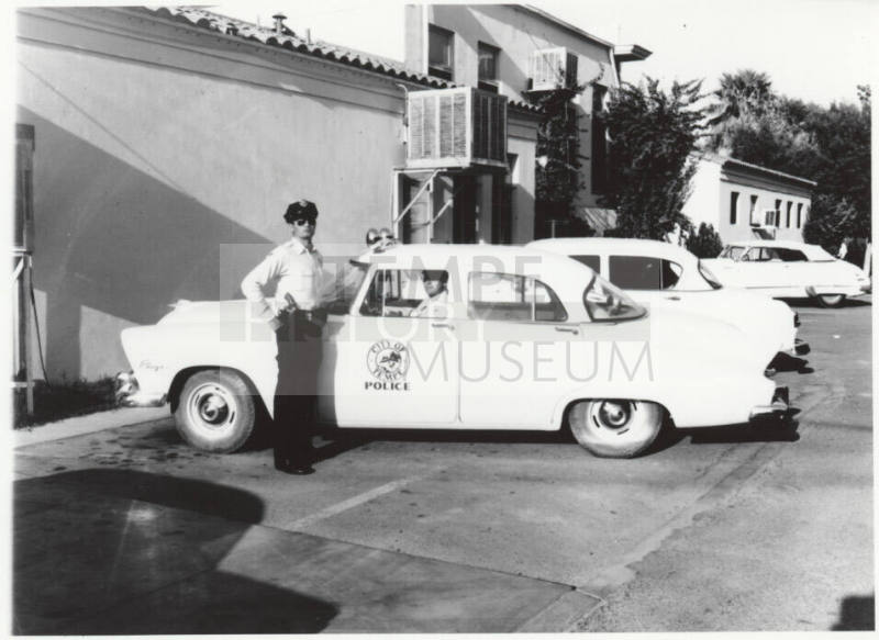 Police car and officers behind the Tempe police station