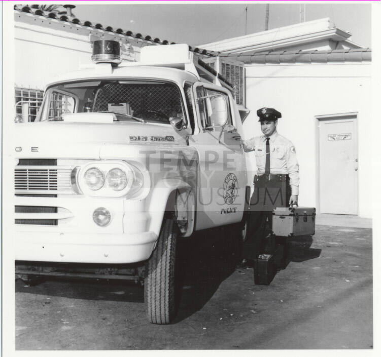 Police officer and vehicle behind the Tempe Police station