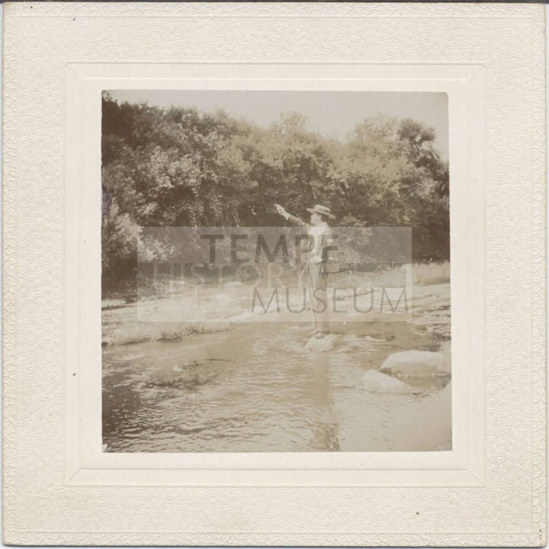 Man with Firearm Standing by Stream