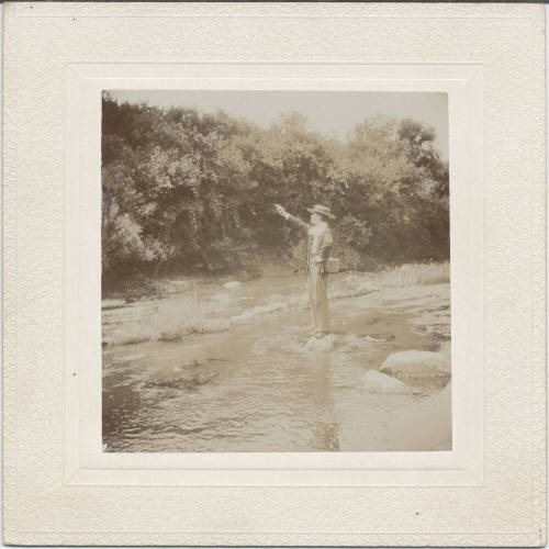 Man with Firearm Standing by Stream
