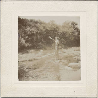 Man with Firearm Standing by Stream