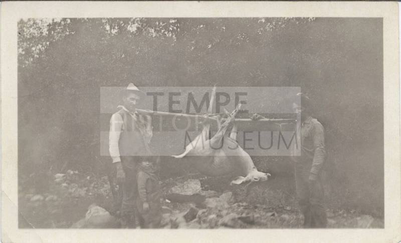 Two Hunters Carrying a Deer