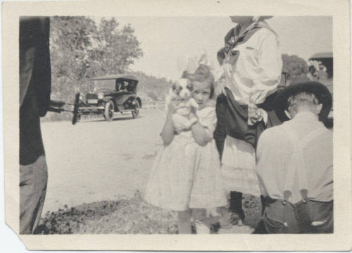 People Beside Road with Passing Cars