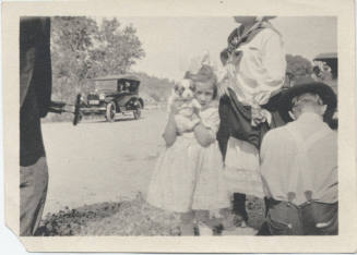 People Beside Road with Passing Cars