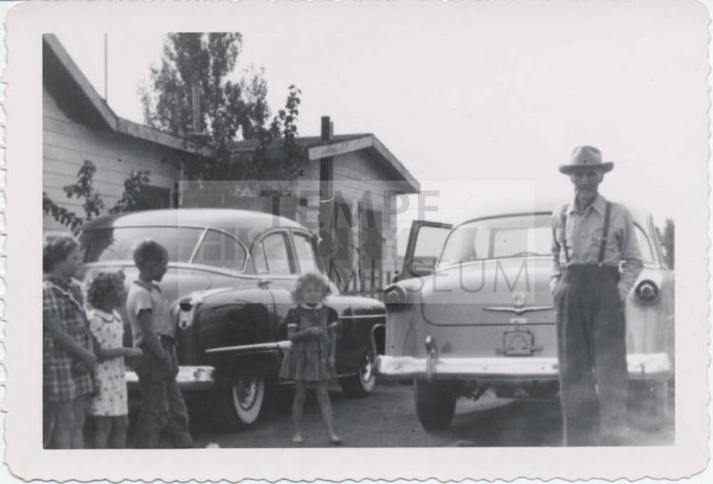 Four Children and a Man Behind Two Cars