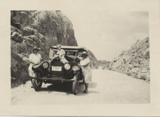 Two Women and Boy by Parked Car on Road