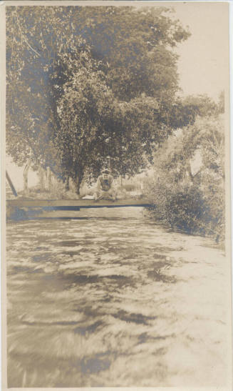Woman Sitting on Bridge Over Canal