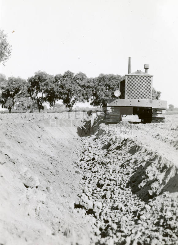 Front View of Tractor Pulling Ditch Plow
