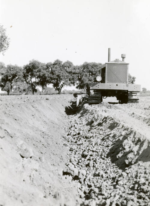 Front View of Tractor Pulling Ditch Plow