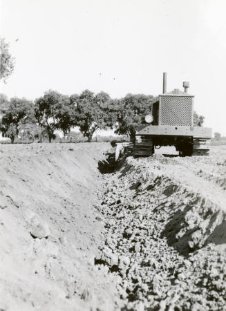 Front View of Tractor Pulling Ditch Plow