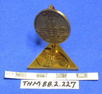 Paperweight of brass with a revolving medallion: Nova, St. Lukes Hospital, 1987