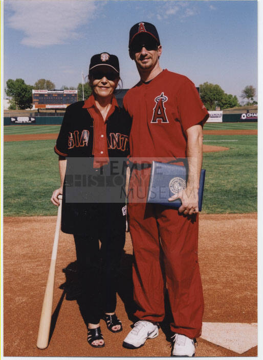 Photo of Mayor Giuliano in a Baseball Uniform with someone in Giant Fan clothing.