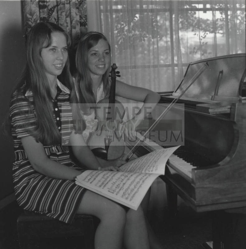 Two Teenage Girls Sitting at a Piano