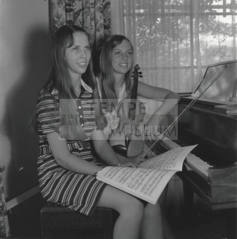 Two Teenage Girls Sitting at a Piano