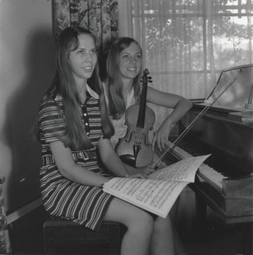 Two Teenage Girls Sitting at a Piano