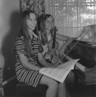 Two Teenage Girls Sitting at a Piano