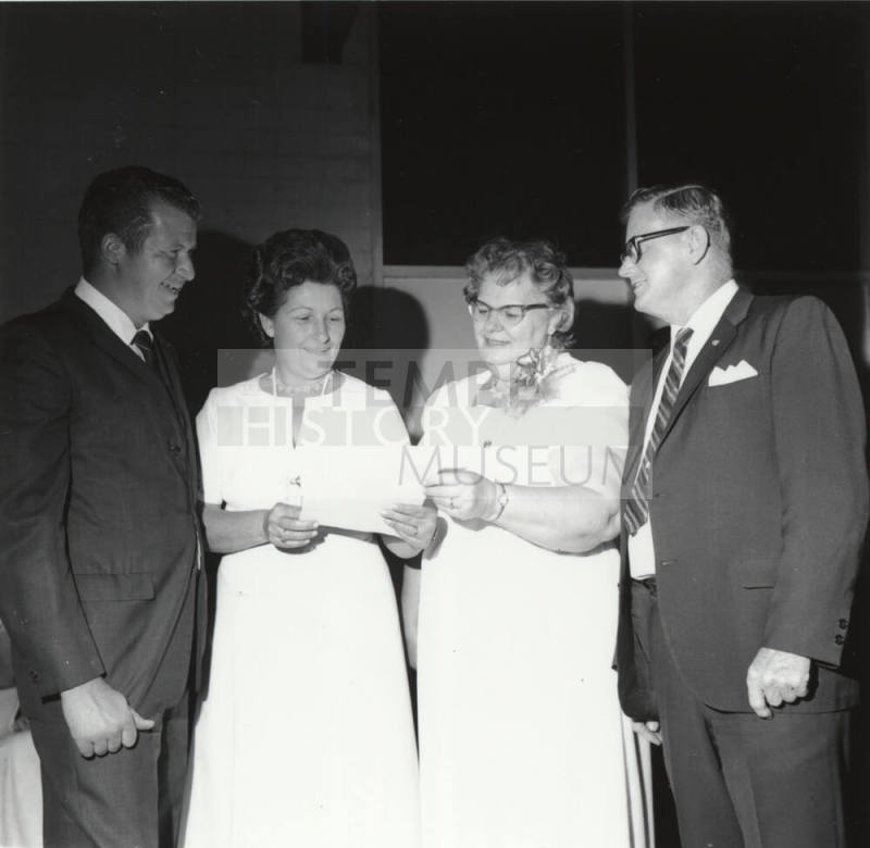 Two Men and Two Women Looking at a Paper (1 of 2)