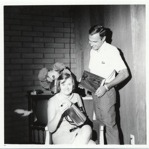 Man and Woman Posed with Plaque and Coffee Pot