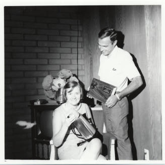 Man and Woman Posed with Plaque and Coffee Pot