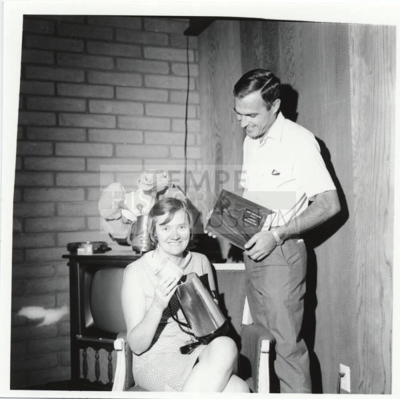 Man and Woman Posed with Plaque and Coffee Pot