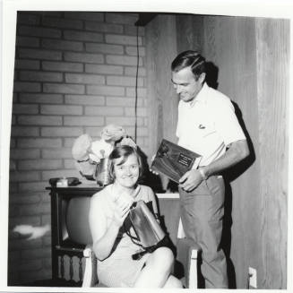 Man and Woman Posed with Plaque and Coffee Pot