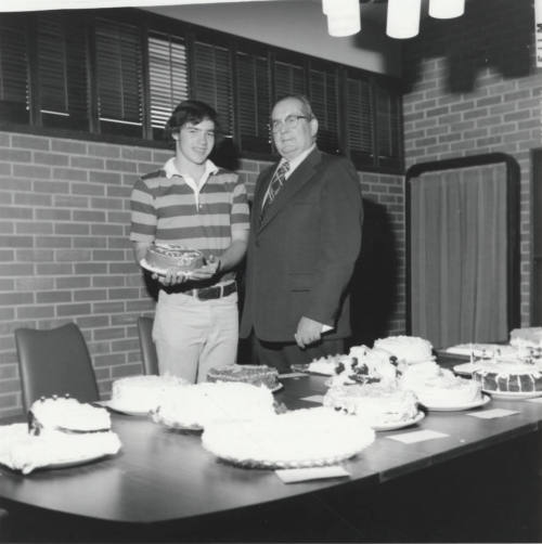 Male student and Bill Boyle with cakes