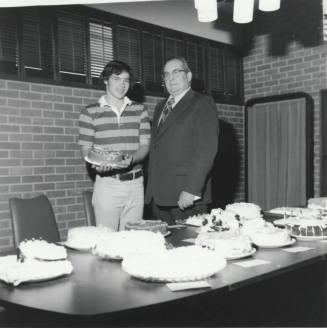 Male student and Bill Boyle with cakes