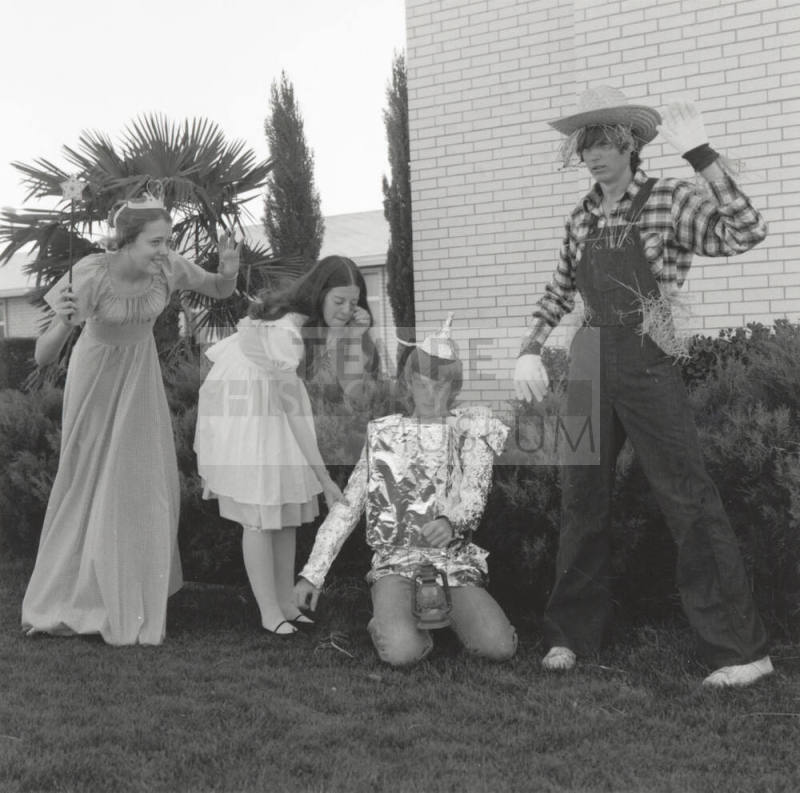 Four people dressed up for 'An Evening in Oz' at Tempe Stake Green and Gold Ball