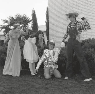 Four people dressed up for 'An Evening in Oz' at Tempe Stake Green and Gold Ball