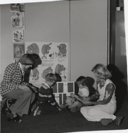 Two children and two women seated on the ground