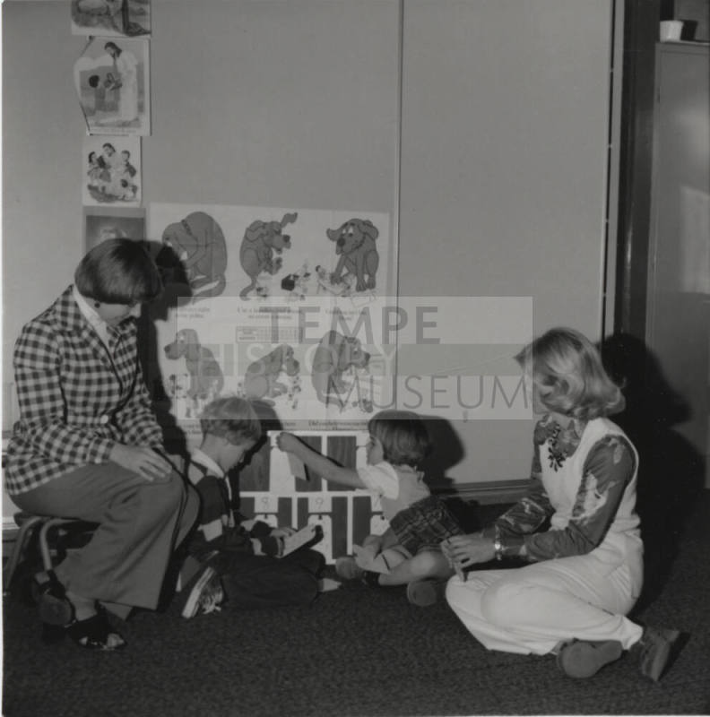 Two children and two women seated on the ground