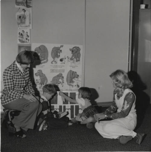 Two children and two women seated on the ground