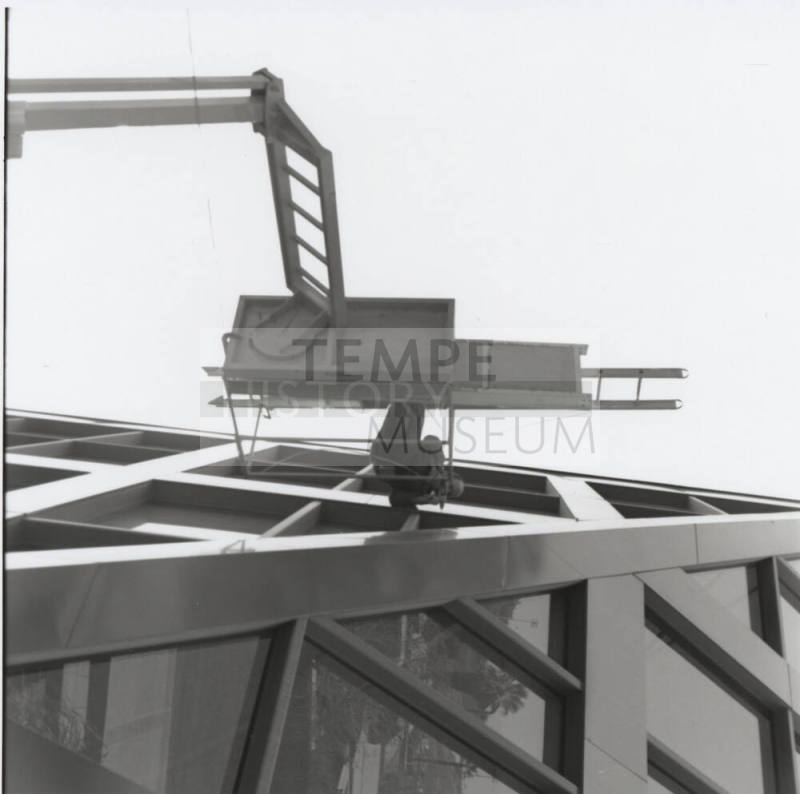 Maintenance worker on elevated platform working on the Tempe City Hall facade