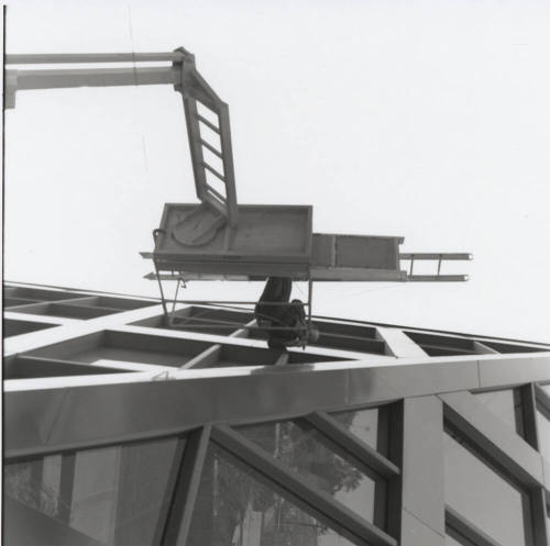 Maintenance worker on elevated platform working on the Tempe City Hall facade