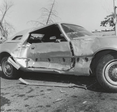 Wrecked Car on Rural Road, with passenger side damage.