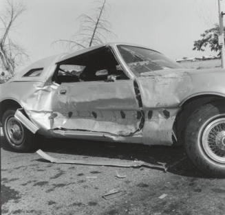 Wrecked Car on Rural Road, with passenger side damage.