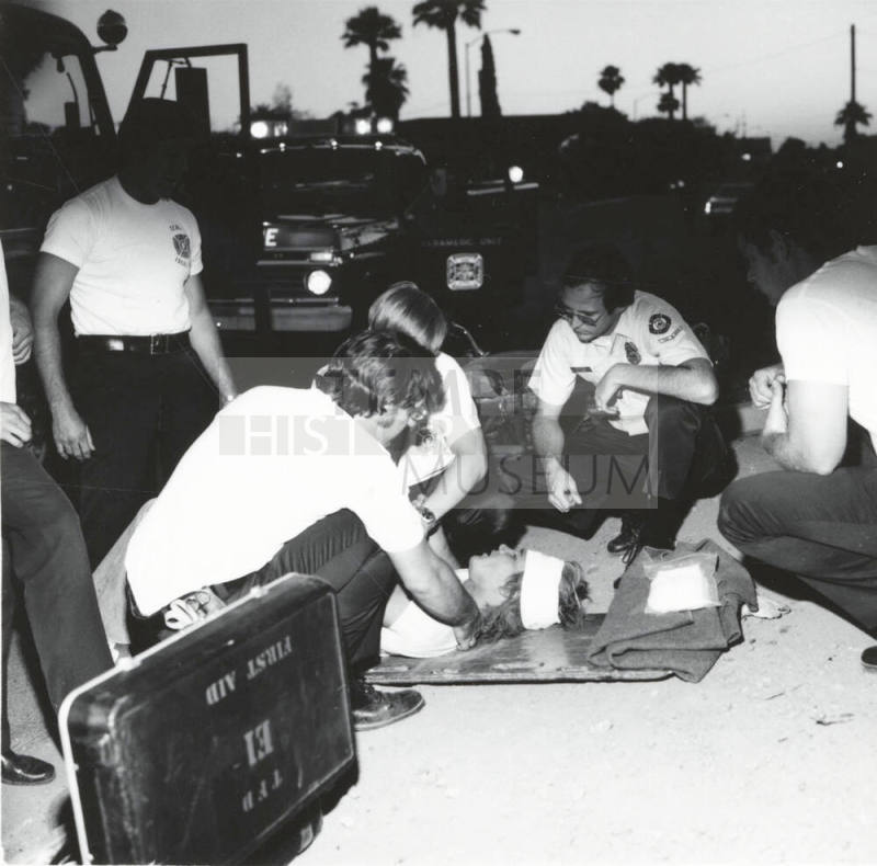 Paramedics helping a man. - May 1977