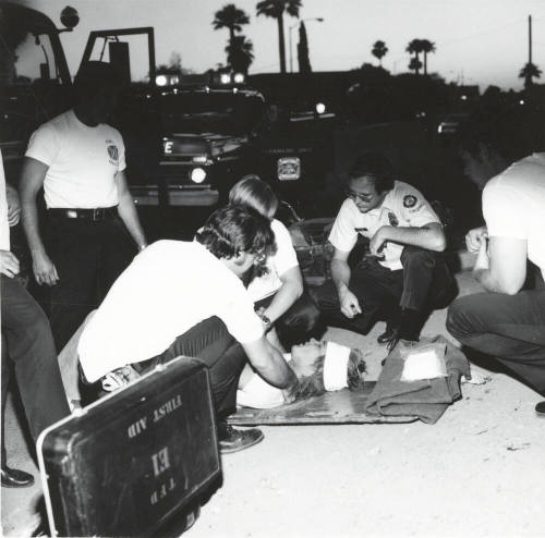 Paramedics helping a man. - May 1977
